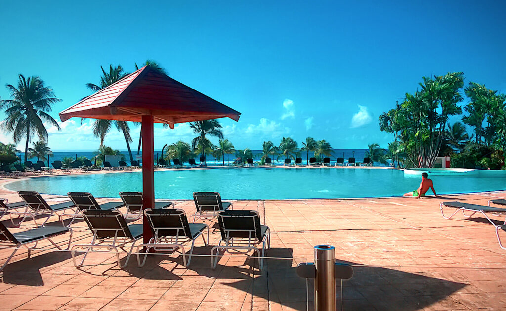 Parasol et piscine dans un hôtel en Guadeloupe avec fond de mer