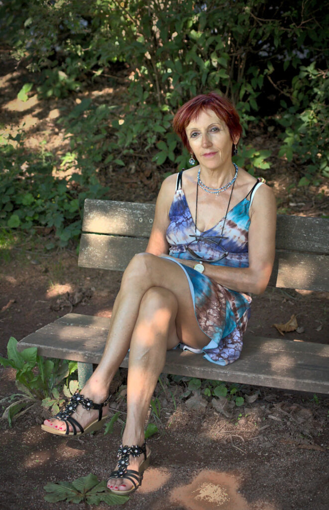 Femme assise sur un banc, les jambes croisées
