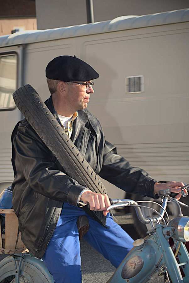 conducteur de motocyclette avec un pneu en bandouiliere