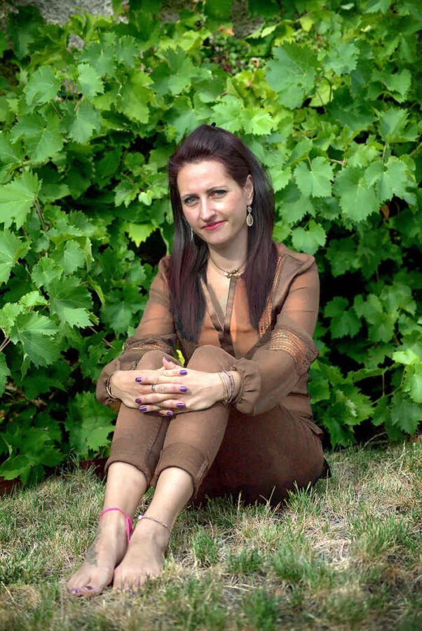 jeune modele feminin assise au pied de champ de vigne les pieds nus