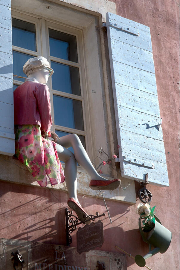 Mannequin factice sur le bord d'une fenêtre d'une maison