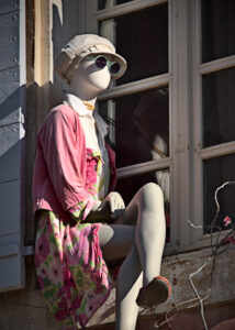 Mannequin en cire sur le rebord d'une fenêtre