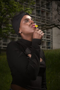 Portrait de femme guadeloupéenne avec une fleur au bord des lèvres